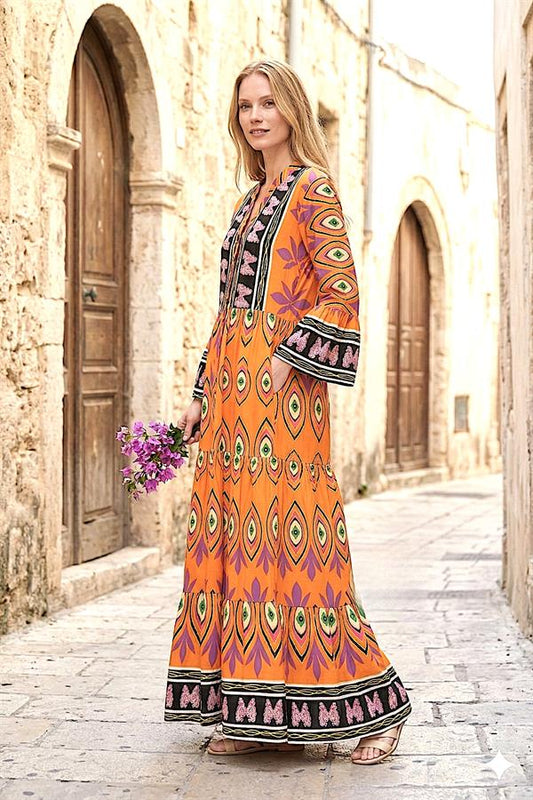 Turuncu renkli, desenli, V yaka, volanlı kollu ve kat kat etekli uzun viskon elbise.