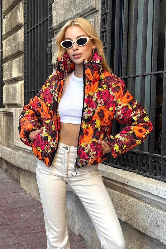 Turuncu dik yakalı, çiçek desenli ve kısa kesim şişme mont.