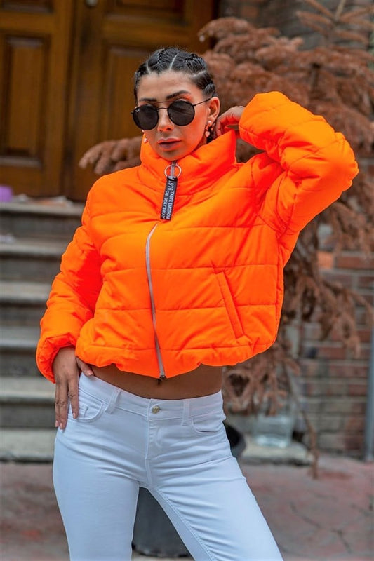 Turuncu renkli, dik yakalı, fermuarlı ve kısa kesim şişme mont.