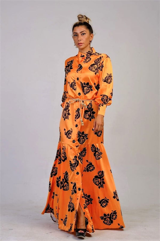 Turuncu renkli, hakim yakalı, siyah çiçek desenli, düğmeli ve hasır kemerli saten uzun elbise.
