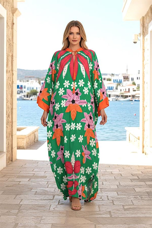Yeşil zemin üzerine pembe ve turuncu çiçek desenli, sıfır yaka, yarasa kollu uzun viskon elbise.