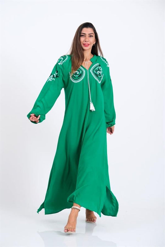 Yeşil renkli, göğüs ve kol kısımları nakışlı, püskül detaylı ve uzun balon kollu elbise.