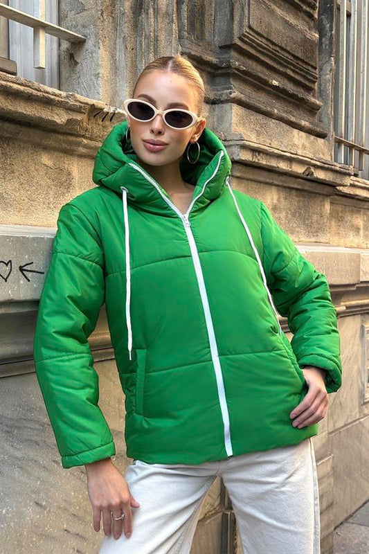 Beyaz fermuarlı ve kapüşonlu yeşil şişme mont.