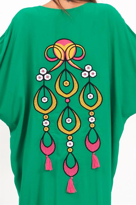 Sırtında renkli otantik nakışlar ve püsküller bulunan yeşil oversize uzun gömlek elbise.