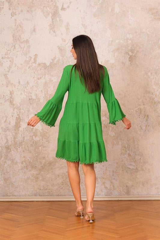 Yeşil renkli, volanlı kolları ve etek ucu ponpon detaylı, kısa bürümcük kumaşlı elbise.