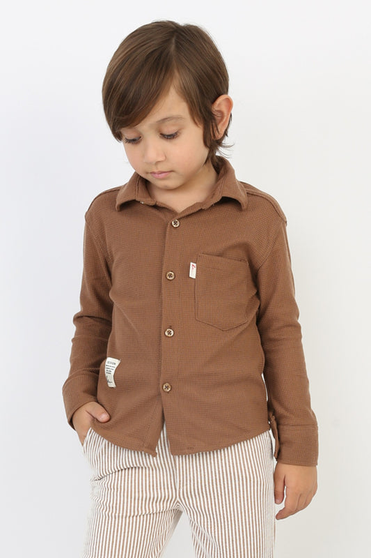 Kahverengi waffle kumaşlı, cepli ve düğmeli erkek çocuk gömleği.