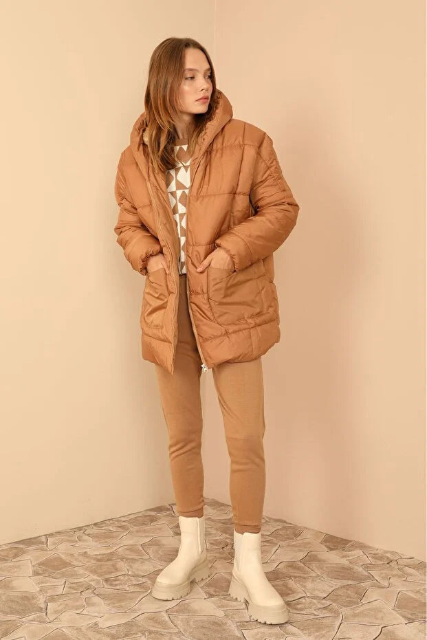 Taba rengi, kapüşonlu, astarlı ve bol kesim kapitone kadın mont.