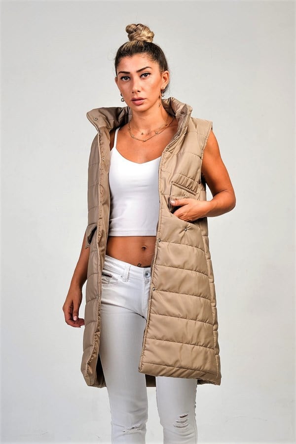 Bej renkli, dik yakalı, çıtçıtlı ve cepli uzun şişme yelek.