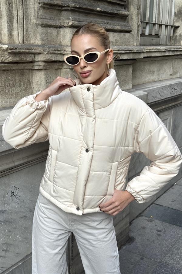 Bej renkli, dik yakalı, çıtçıtlı ve fermuarlı kısa şişme mont.