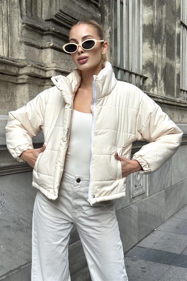 Bej renkli, dik yakalı, fermuarlı ve çıtçıtlı kısa şişme mont.