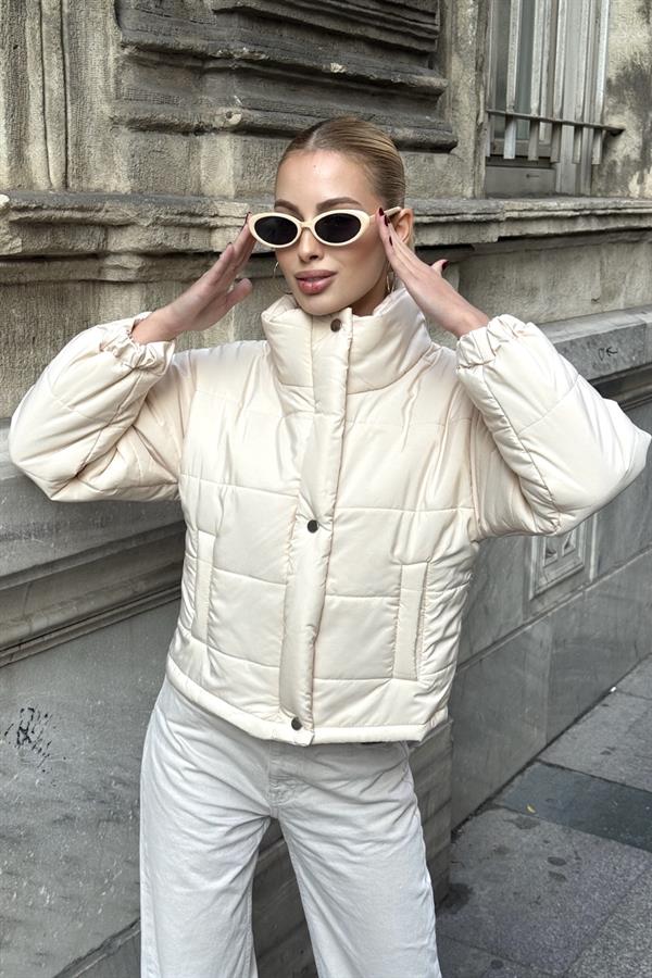 Bej renkli, dik yakalı, çıtçıtlı ve fermuarlı kısa şişme mont.