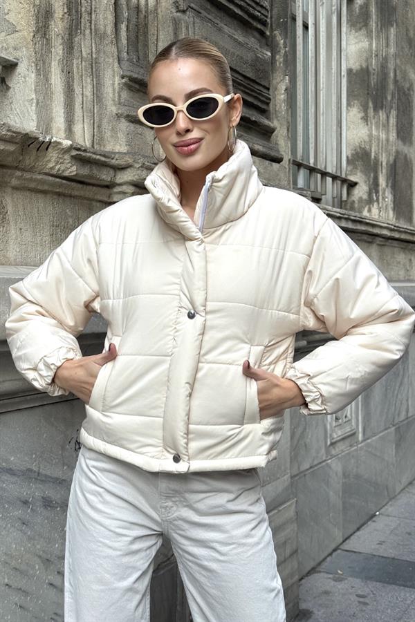 Bej renkli, dik yakalı, çıtçıtlı ve fermuarlı kısa şişme mont.