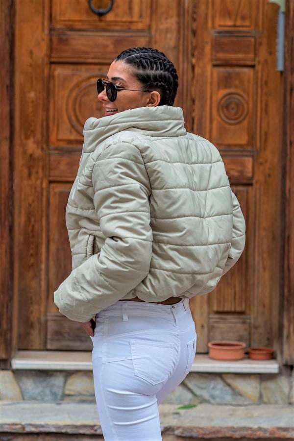 Bej renkli, dik yakalı, su geçirmez ve kısa kesim şişme mont.