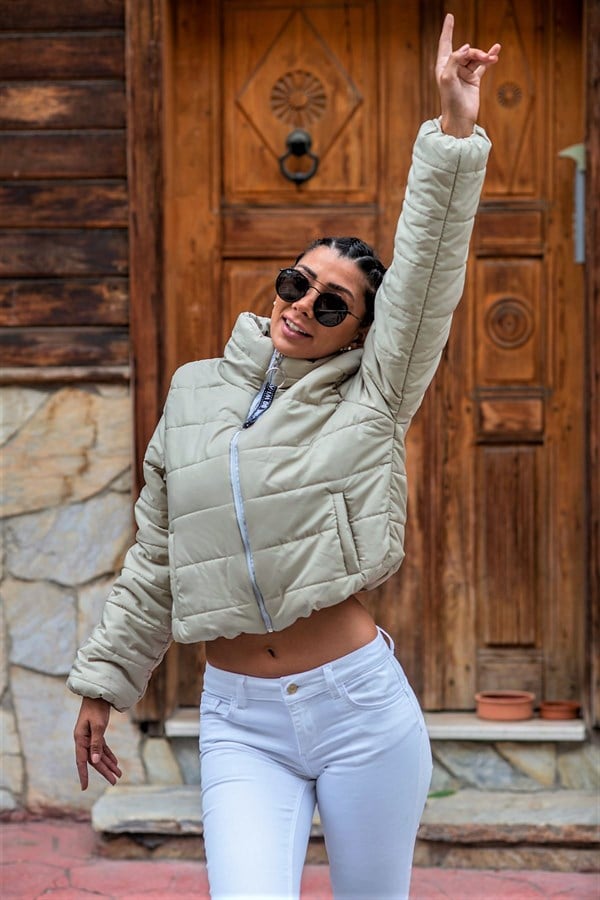 Bej renkli, dik yakalı, su geçirmez ve kısa kesim şişme mont.