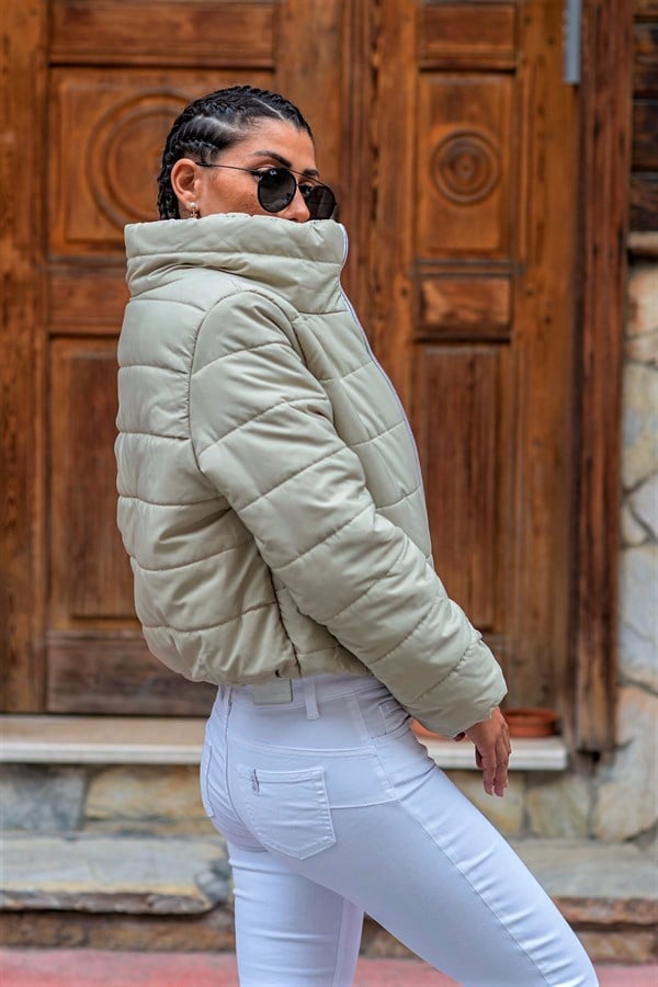 Bej renkli, dik yakalı, su geçirmez ve kısa kesim şişme mont.