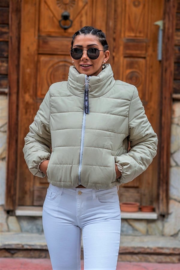 Bej renkli, dik yakalı, fermuarlı ve kısa kesim şişme mont.