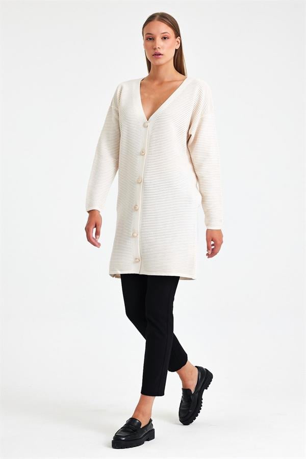 Beyaz renkli, fitilli dokuya sahip, düğmeli ve uzun triko hırka.