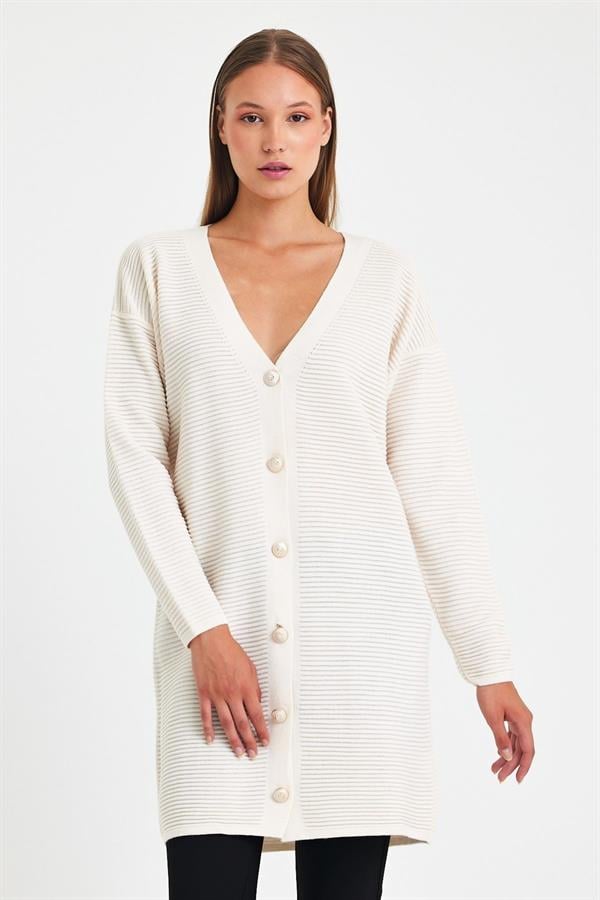 Beyaz renkli, fitilli dokuya sahip, düğmeli ve uzun triko hırka.