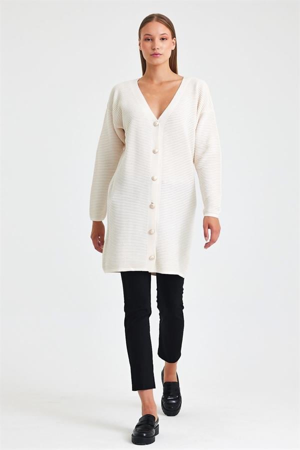 Beyaz renkli, fitilli dokuya ve düğme detaylarına sahip uzun triko hırka.