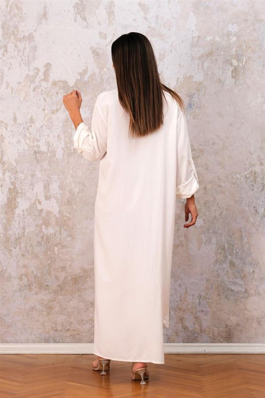 Beyaz renkli, uzun kollu, apoletli ve cepli, viskon kumaştan üretilmiş uzun gömlek elbise.