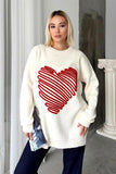 Beyaz renkli, üzerinde kırmızı kabartmalı büyük kalp deseni bulunan uzun triko kazak.