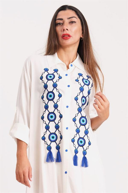 Önü nazar boncuğu nakışlı ve püsküllü, beyaz renkli, uzun kollu gömlek elbise.