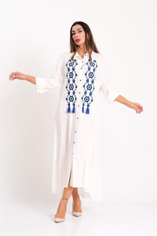 Beyaz renkli, önü nazar boncuğu nakışlı ve püsküllü, fırfır detaylı uzun gömlek elbise.