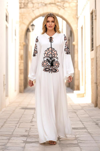 Beyaz, önü ve kolları otantik nakışlı, püskül bağlamalı ve balon kollu uzun elbise.