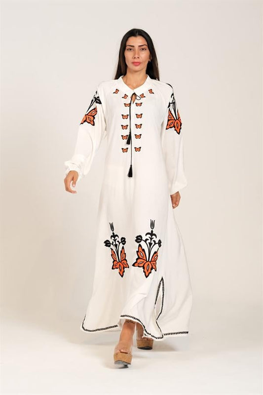 Beyaz, sıfır yaka, balon kollu ve turuncu-siyah otantik nakış detaylı uzun viskon elbise.