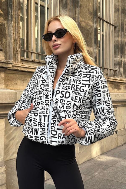 Siyah yazılı, dik yakalı, kısa ve beyaz renkli şişme mont.