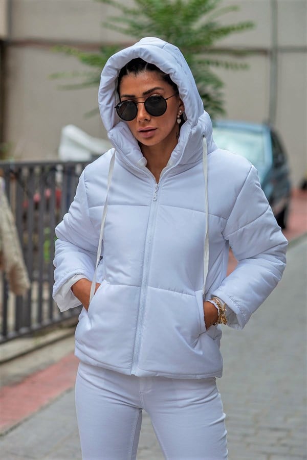 Beyaz renkli, kapüşonlu ve fermuarlı, su geçirmez kumaştan üretilmiş şişme mont.