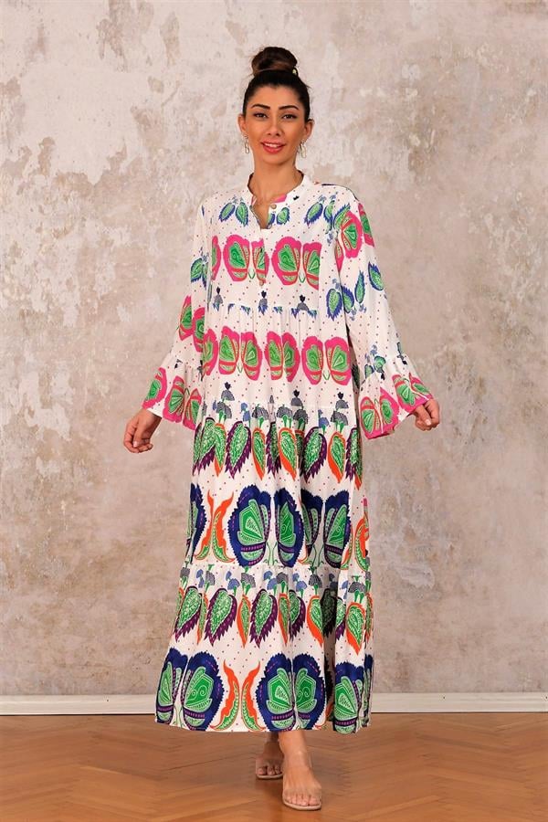 Beyaz zemin üzerine renkli tropikal desenli, volanlı kollu ve kat kat etekli uzun elbise.