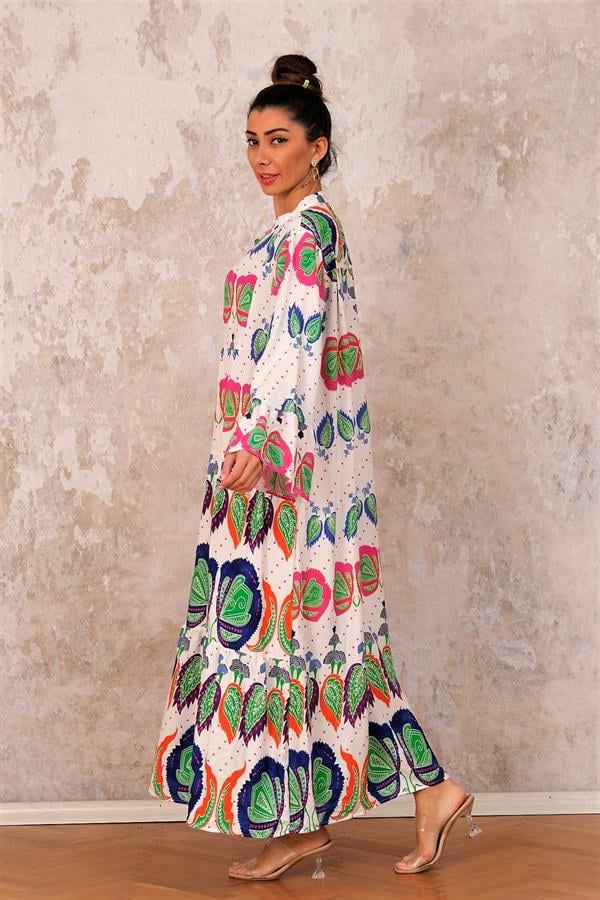 Beyaz zemin üzerine renkli tropikal desenli, volanlı kollu ve kat kat etekli uzun viskon elbise.