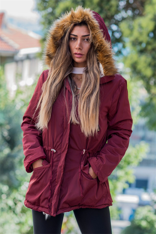Bordo renkli, içi kürklü, kapüşonu suni kürk detaylı ve beli büzülebilen su geçirmez mont.