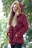 Bordo renkli, içi kürklü, kapüşonu suni kürk detaylı ve beli büzülebilir su geçirmez mont.