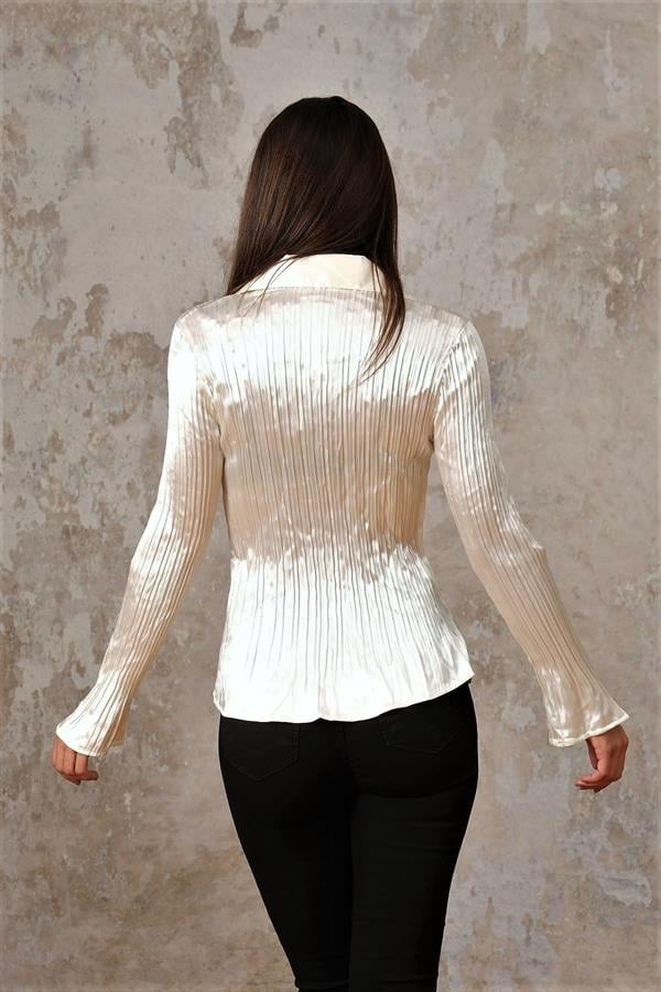 Ekru renkli, saten kumaştan üretilmiş, piliseli detaylara sahip uzun kollu gömlek.