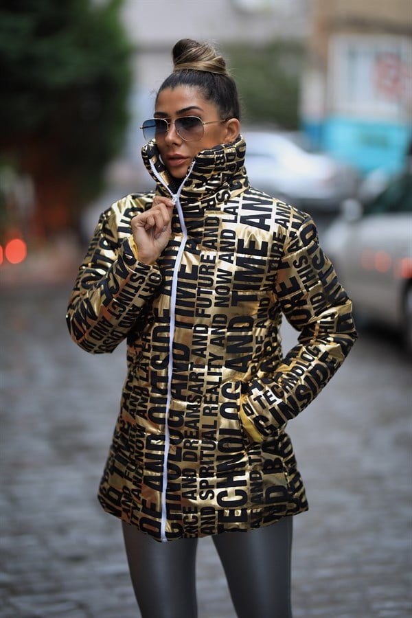 Siyah yazılı desenlere sahip, dik yakalı, parlak gold renkli uzun şişme mont.