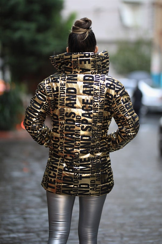 Siyah yazılı desenlere sahip, dik yakalı, parlak gold renkli uzun şişme mont.