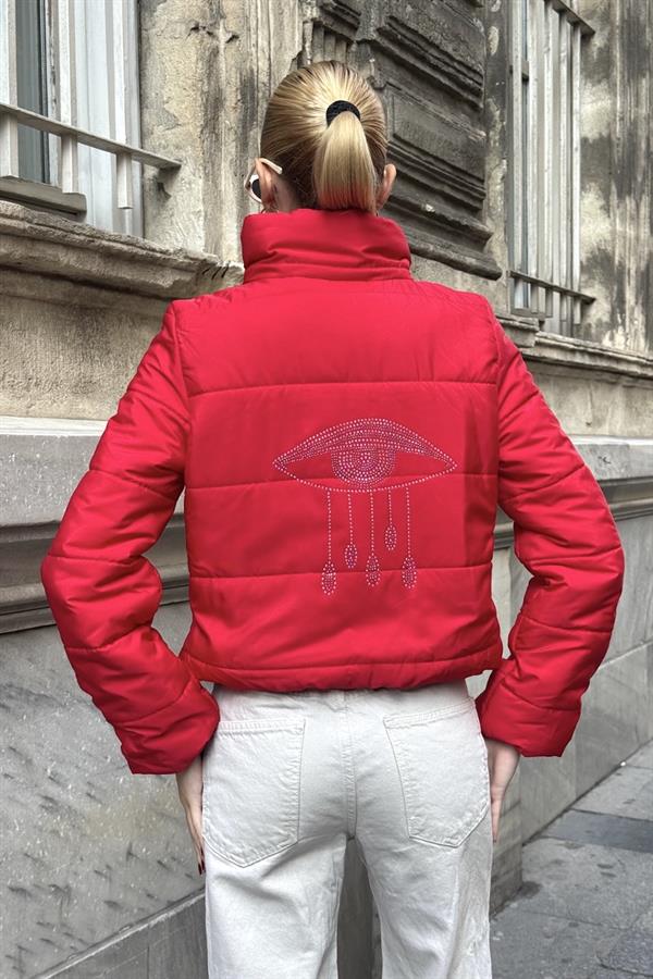 Sırtında taş işlemeli göz detayı bulunan kırmızı, dik yakalı, kısa şişme mont.