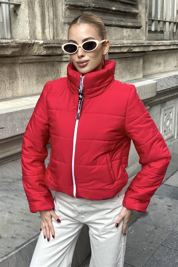 Dik yakalı, beyaz fermuarlı ve kırmızı renkli kısa şişme mont.