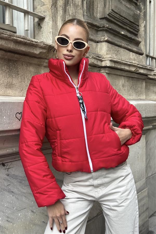 Kırmızı renkli, dik yakalı, beyaz fermuarlı ve kısa kesim şişme mont.