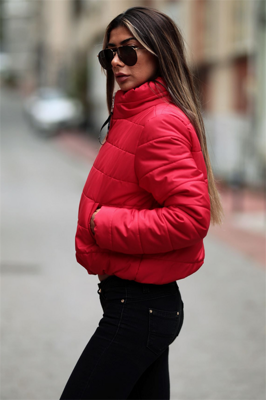 Kırmızı renkli, dik yakalı, su geçirmez ve kısa kesim şişme mont.