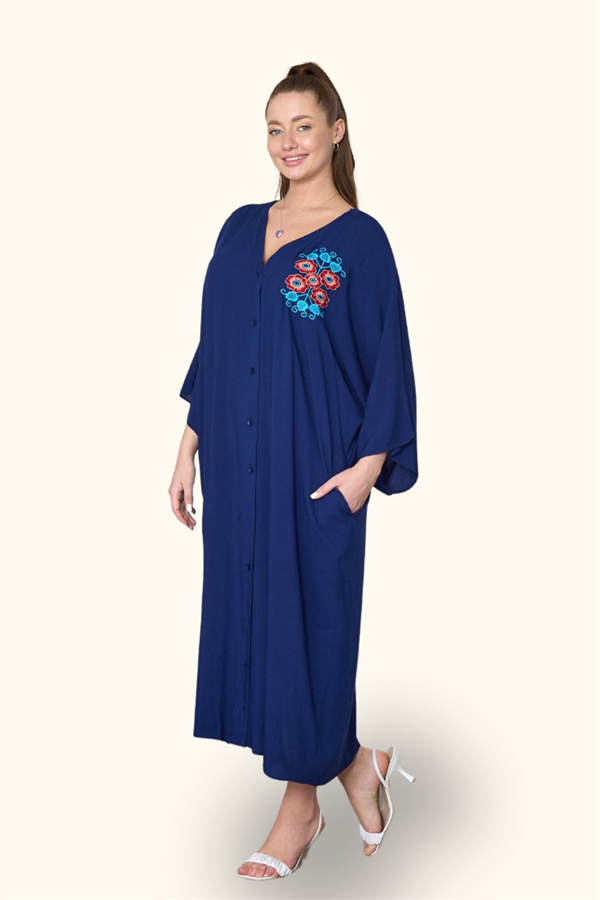 A model wears a navy blue oversized button-down midi dress with floral embroidery and pockets.