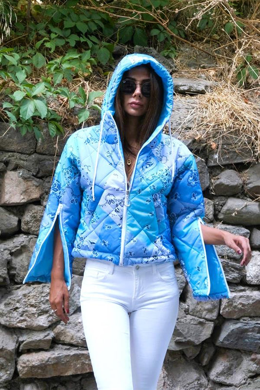 Mavi desenli, kapüşonlu, kolları fermuarlı ve kısa kesim şişme mont.