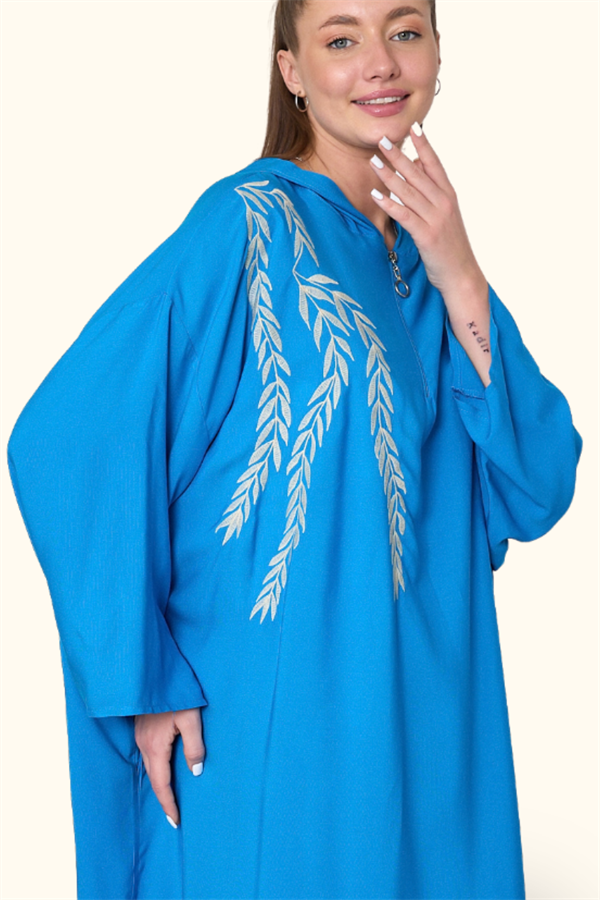 Mavi renkli, kapüşonlu, fermuarlı ve göğüs kısmında nakış detayları bulunan oversize uzun elbise.