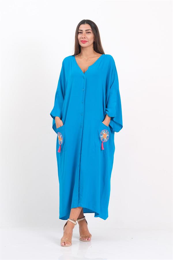 A model wears a blue, button-front, V-neck oversized dress with embroidered, tasseled pockets.
