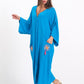 A model wears a blue V-neck oversized long dress with embroidered pockets and tassels.