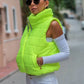 Neon yeşil renkli, dik yakalı, fermuarlı ve cepli kısa şişme yelek.