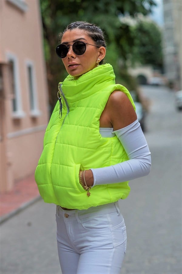 Neon yeşil renkli, dik yakalı, fermuarlı ve cepli kısa şişme yelek.