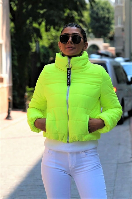 Neon yeşil renkli, dik yakalı, fermuarlı ve kısa kesim şişme mont.